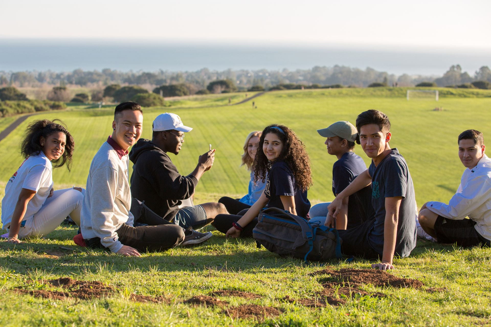 Group of students on a hillside hanging out.