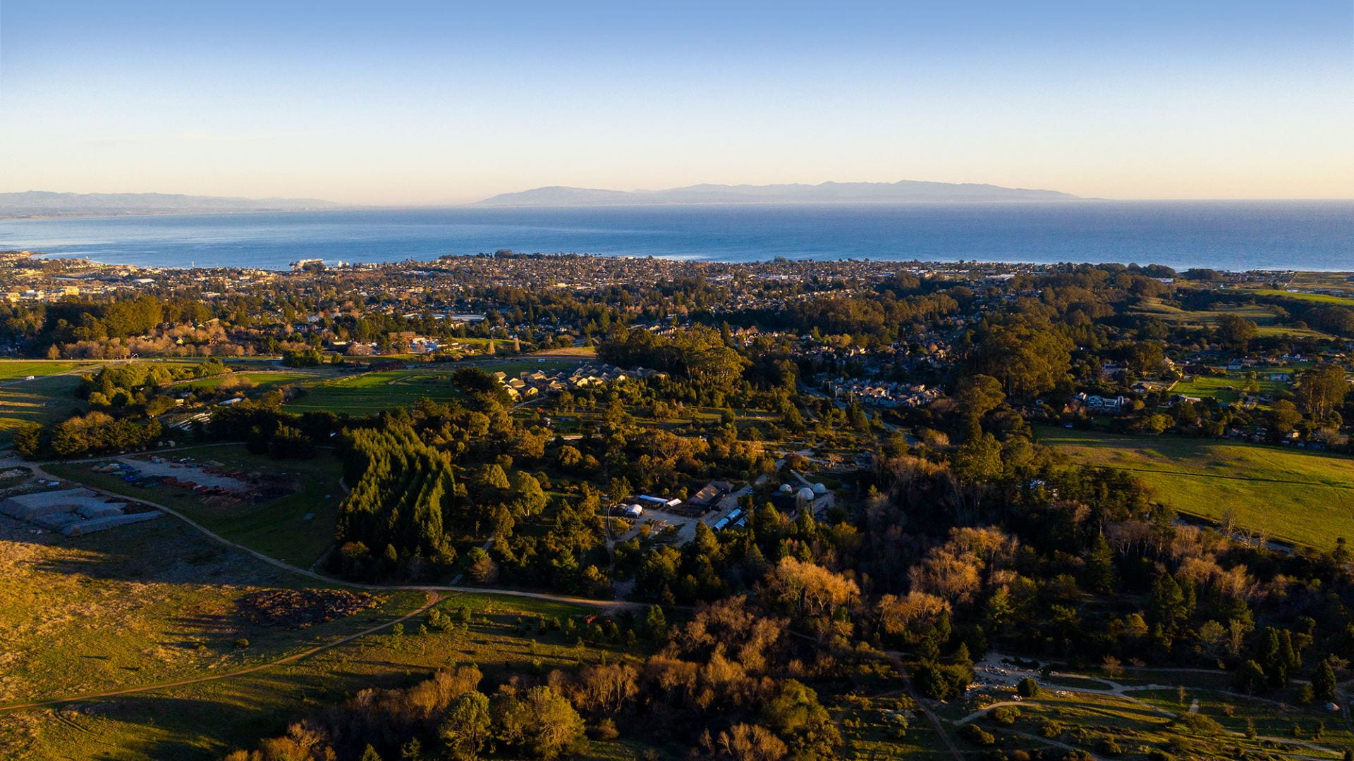 Aerial image with campus in the foreground and the Monterey Bay in the background.